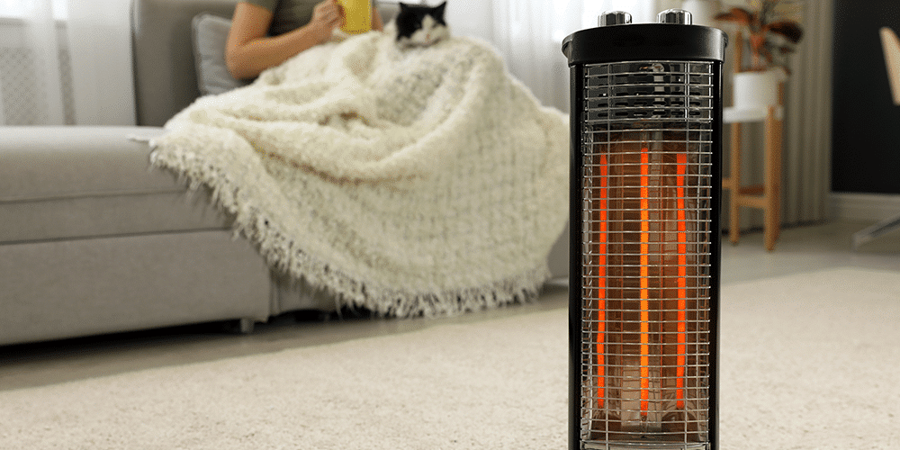 Space heater stands in middle of living room with female homeowner and cat on the couch in background.